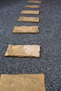 The Stone walk path in the park with grey small stones on background