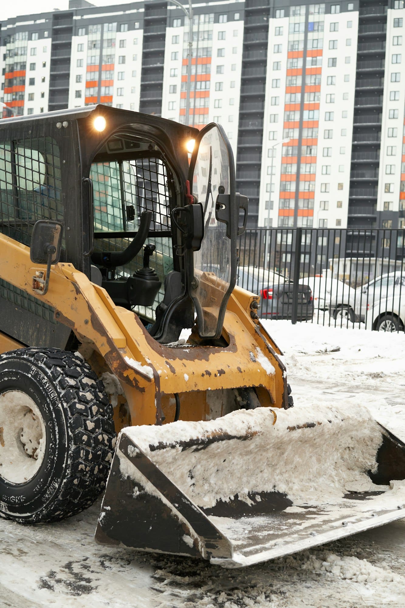 Excavator shovels snow on the road with a bucket