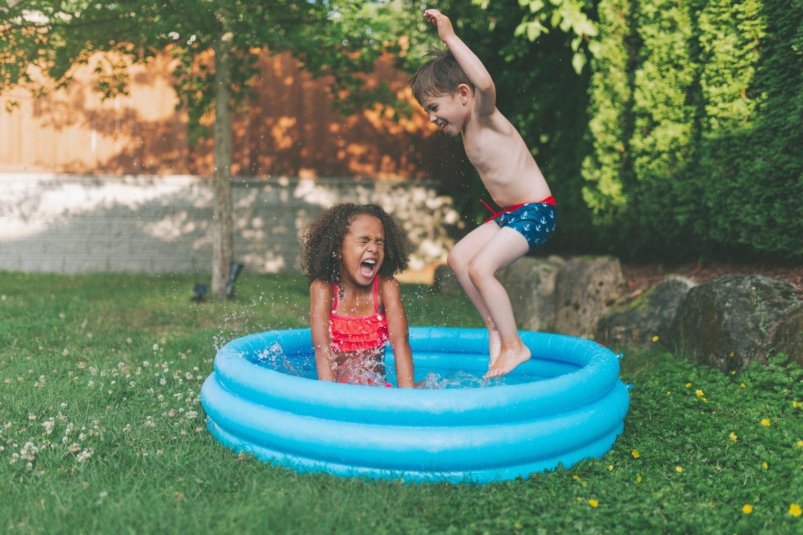 Diverse kids playing in the backyard in summer.